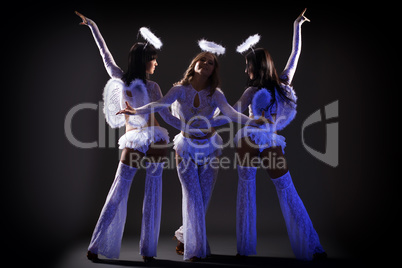 Trio of sexy female dancers posing under UV light