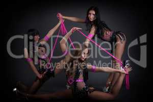 Young dancers posing in erotic costumes with ropes