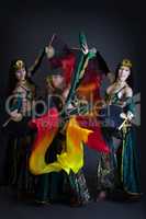 Graceful belly dancers posing with colorful fans