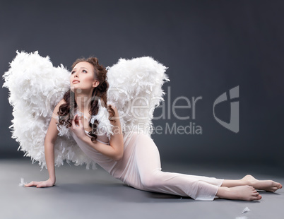Beautiful sad woman posing in angel costume