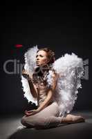 Charming young woman posing dressed as angel