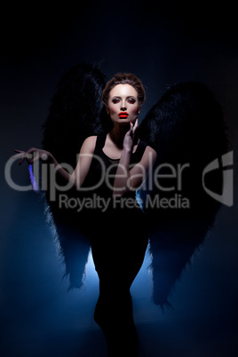 Beautiful model posing in suit of fallen angel