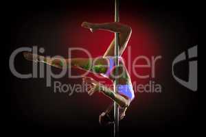 Athletic young girl posing upside down on pylon