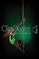Studio shot of elegant slim girl dancing on pole