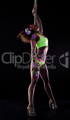 Graceful dancer with neon makeup posing near pylon
