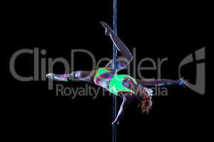 Lovely girl with luminous makeup dancing on pole