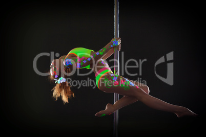 Graceful red-haired young woman dancing on pole