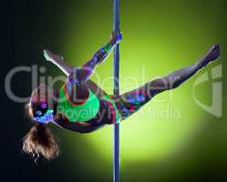 Muscular woman with neon makeup dancing on pole