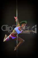 Contemporary active go-go dancer posing on pylon