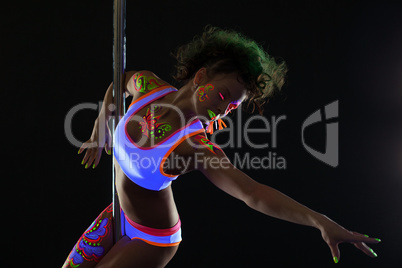 Artistic pole dancer with neon pattern on body
