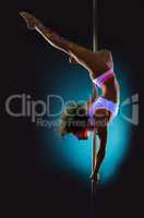 Flexible contemporary dancer exercising on pole