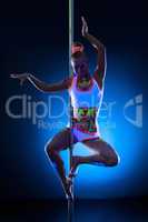 Graceful young pole dancer with fluorescent makeup