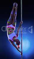 Charming dancer hanging upside down on pylon