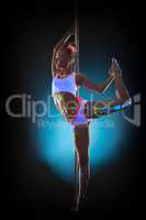 Energetic girl with glowing makeup dancing on pole