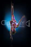 Cute flexible girl hanging upside down on pylon