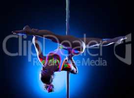 Flexible slim girl doing splits on pylon