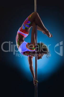Slender young woman dancing on pole