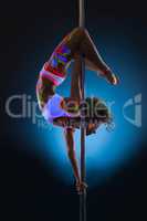 Slender young woman dancing on pole