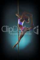 Young graceful woman dancing on pole