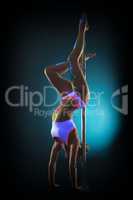 Skinny flexible pole dancer standing on hands