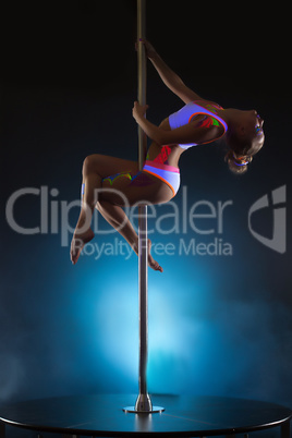 Image of slender young girl dancing on pole