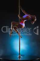 Image of slender young girl dancing on pole