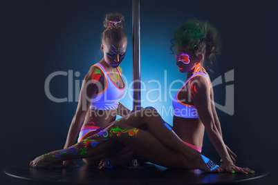 Two modern pole dancers with UV makeup