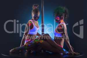 Two modern pole dancers with UV makeup