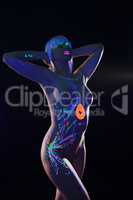 Slim girl posing nude with glowing pattern on body