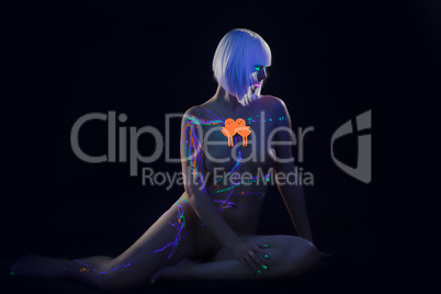 Curvy young girl posing nude under neon light