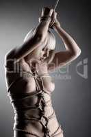 Portrait of sexy slim blonde posing tied with rope
