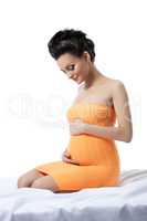 Elegant pregnant woman posing in studio