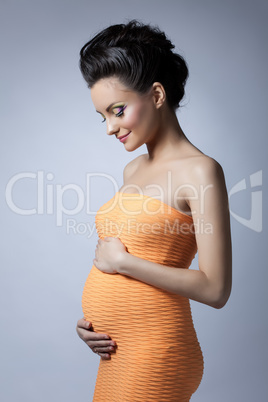 Beautiful elegant pregnant woman posing in studio