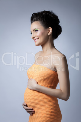 Smiling expectant mother posing in stylish dress