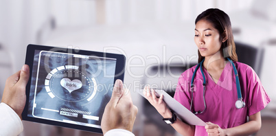 Composite image of asian nurse with stethoscope looking at the c