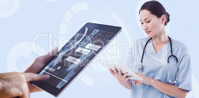 Composite image of surgeon using digital tablet with group aroun