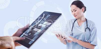 Composite image of surgeon using digital tablet with group aroun