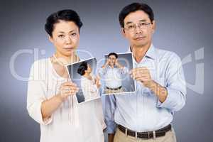 Composite image of asian couple holding a photo