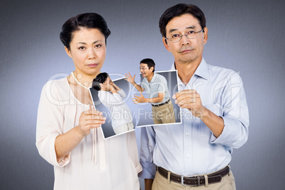 Composite image of asian couple holding a photo