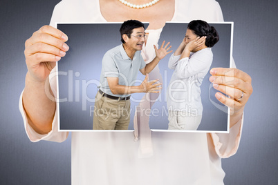 Composite image of woman holding a torn photo