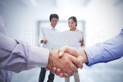 Composite image of men shaking hands