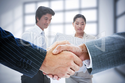 Composite image of business people shaking hands