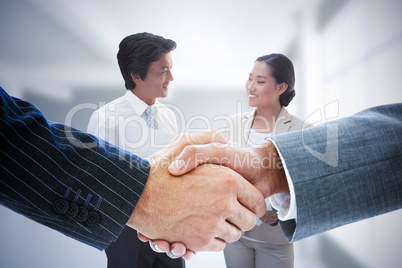 Composite image of business people shaking hands