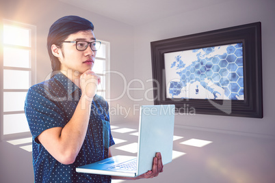 Composite image of thoughtful hipster using his laptop