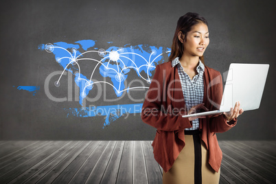 Composite image of smiling businesswoman using laptop