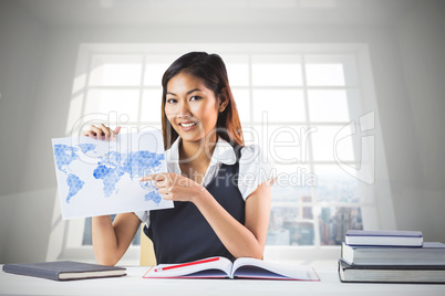 Composite image of smiling businesswoman pointing a sheet of pap