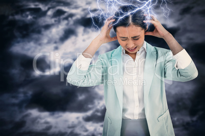 Composite image of worried businesswoman holding her head