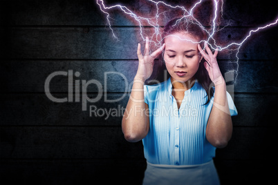 Composite image of worried businesswoman holding her head