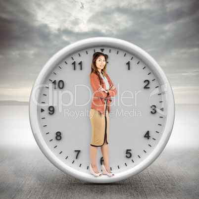 Composite image of smiling businesswoman with crossed arms