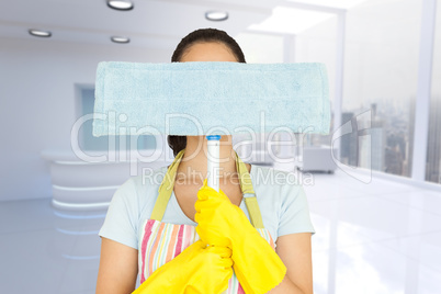 Composite image of young woman hiding behind mop
